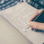 Hand completing a structured career planning checklist